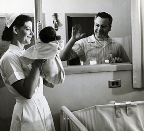A nurse showing a newborn baby to its father, illustrating the nine classes of the Conception to Delivery program offered by Baby Steps.